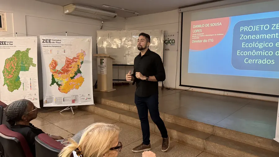 Apresentação do zoneamento em audiência pública, ao lado dos mapas impressos do projeto.
